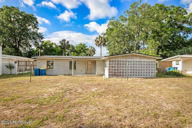 back of property featuring fence, stucco siding, and a yard