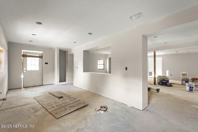 unfurnished living room with a textured ceiling and a wealth of natural light