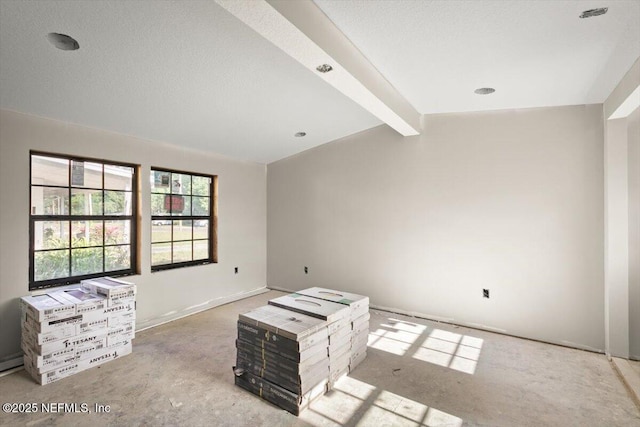 empty room with vaulted ceiling with beams