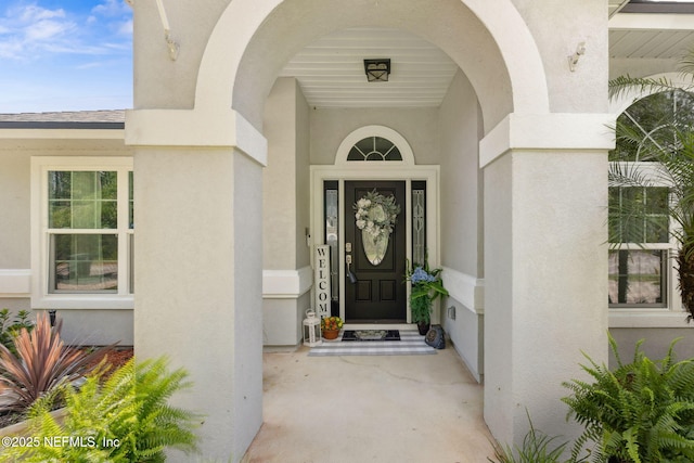 view of exterior entry with stucco siding