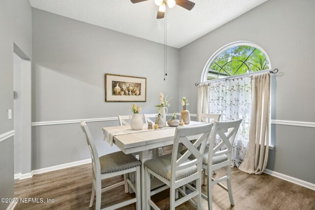 dining room with baseboards, a ceiling fan, and wood finished floors