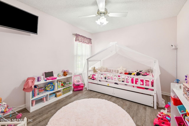bedroom featuring a textured ceiling, a ceiling fan, and wood finished floors