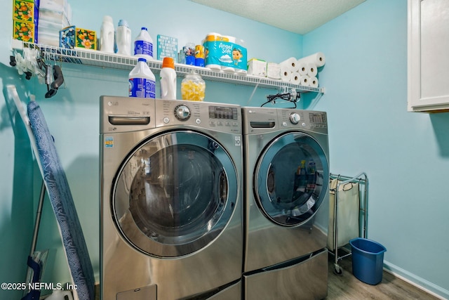 clothes washing area featuring cabinet space, separate washer and dryer, baseboards, and wood finished floors