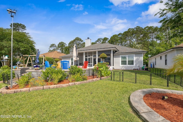 view of front facade with fence, a sunroom, a front yard, a gate, and a chimney