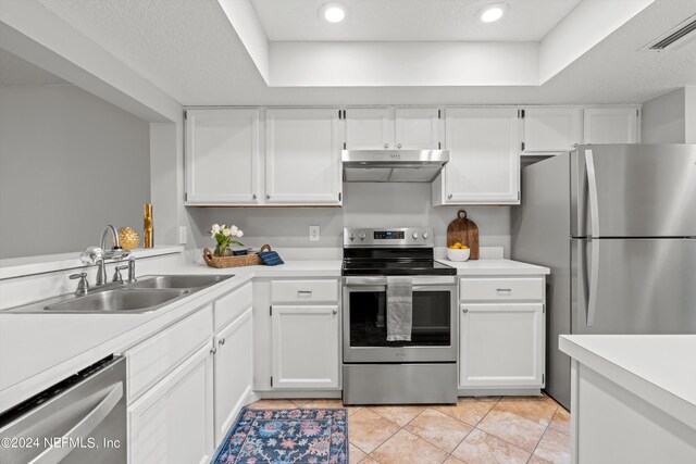 kitchen featuring stainless steel appliances, under cabinet range hood, a sink, light countertops, and recessed lighting