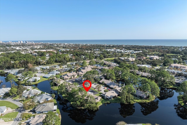 aerial view of property and surrounding area with a large body of water and nearby suburban area