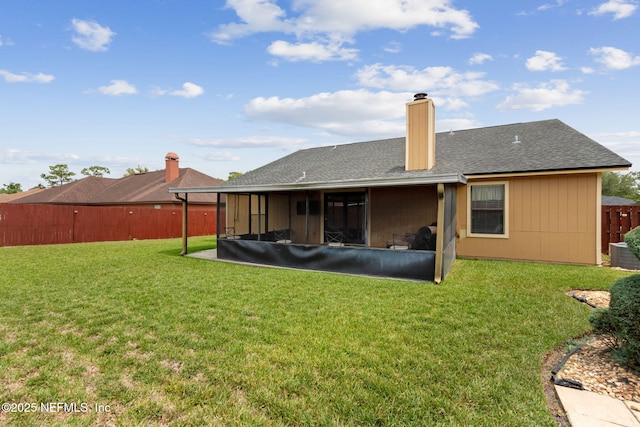 rear view of property with a yard, fence, a chimney, and roof with shingles