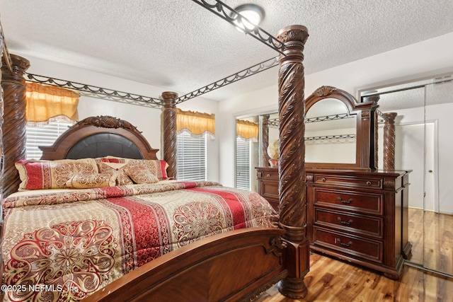 bedroom featuring light wood-type flooring and a textured ceiling