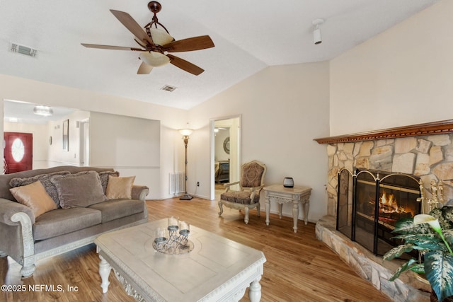 living area with visible vents, a ceiling fan, light wood-style flooring, and lofted ceiling