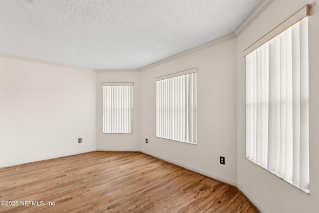 empty room featuring ornamental molding, a textured ceiling, and wood finished floors
