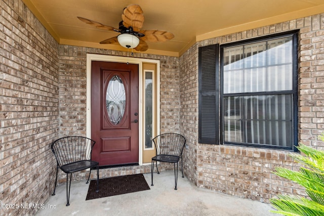 property entrance featuring brick siding, ceiling fan, and a porch