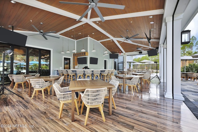 dining space with a ceiling fan, wood ceiling, wood finished floors, and high vaulted ceiling