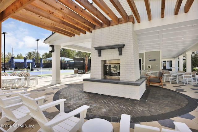 view of patio / terrace featuring fence and an outdoor brick fireplace