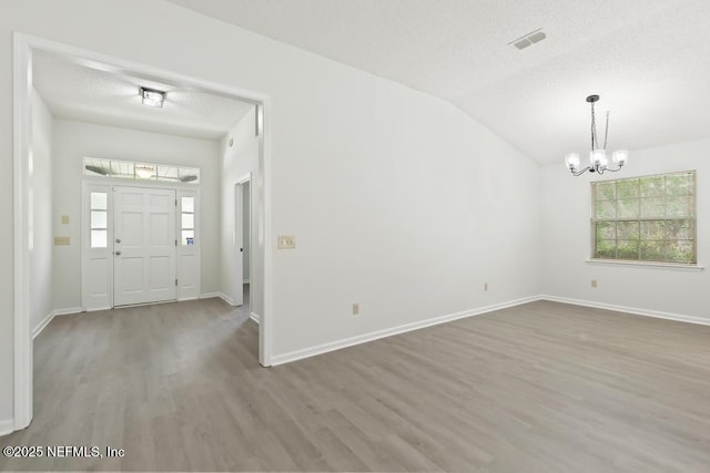 11598 Lazy Willow Ln, Jacksonville, FL 32223 - foyer with a chandelier, wood finished floors, plenty of natural light, vaulted ceiling, and a textured ceiling