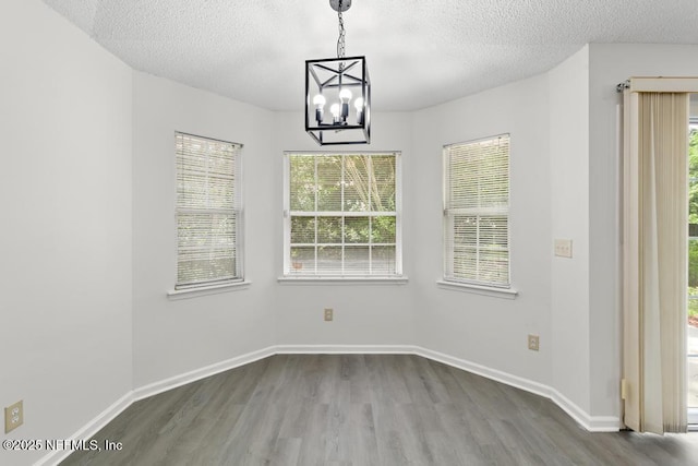 11598 Lazy Willow Ln, Jacksonville, FL 32223 - unfurnished dining area with dark wood-style floors, a textured ceiling, healthy amount of natural light, and a chandelier
