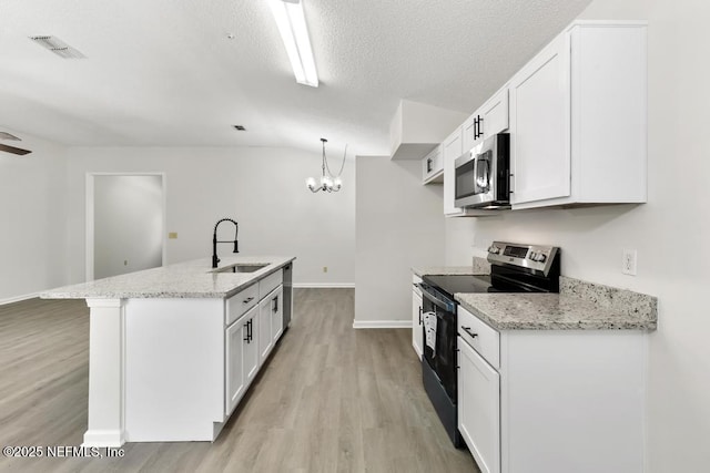 11598 Lazy Willow Ln, Jacksonville, FL 32223 - kitchen with stainless steel appliances, a sink, light wood-type flooring, white cabinetry, and lofted ceiling