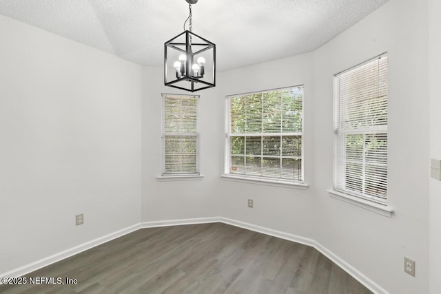 11598 Lazy Willow Ln, Jacksonville, FL 32223 - unfurnished dining area with dark wood-style flooring, a chandelier, baseboards, and a textured ceiling