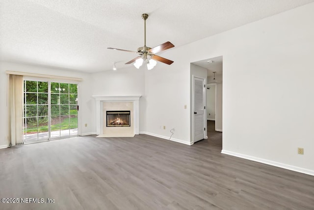11598 Lazy Willow Ln, Jacksonville, FL 32223 - unfurnished living room with wood finished floors, a ceiling fan, baseboards, a fireplace, and a textured ceiling