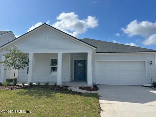 ranch-style home with covered porch, driveway, a front yard, and a garage
