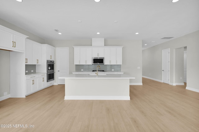 440 Slash Pine Pl, Yulee, FL 32097 - kitchen featuring appliances with stainless steel finishes, light countertops, a center island with sink, backsplash, and recessed lighting