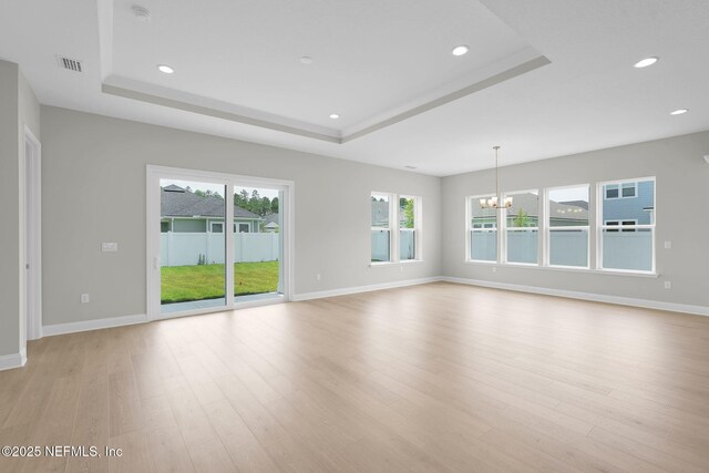 440 Slash Pine Pl, Yulee, FL 32097 - unfurnished room with a chandelier, a tray ceiling, healthy amount of natural light, light wood finished floors, and recessed lighting