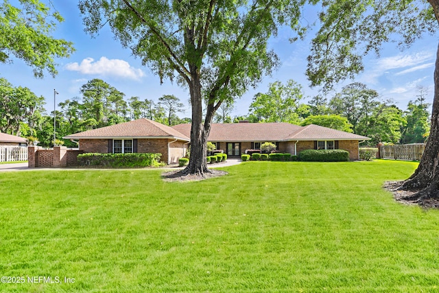 7805 Hunters Grove Rd, Jacksonville, FL 32256 - ranch-style home featuring brick siding, fence, and a front yard
