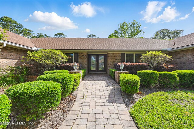 7805 Hunters Grove Rd, Jacksonville, FL 32256 - ranch-style home with brick siding, roof with shingles, and french doors