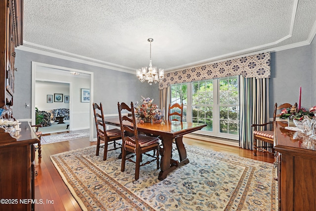7805 Hunters Grove Rd, Jacksonville, FL 32256 - dining area featuring crown molding, a textured ceiling, an inviting chandelier, and wood finished floors