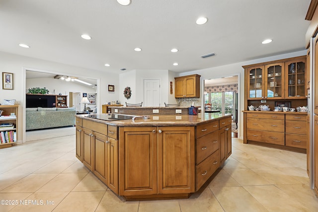 7805 Hunters Grove Rd, Jacksonville, FL 32256 - kitchen with a kitchen island, brown cabinets, black electric cooktop, light tile patterned floors, and recessed lighting
