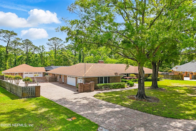 7805 Hunters Grove Rd, Jacksonville, FL 32256 - ranch-style house with decorative driveway, an attached garage, fence private yard, and a front lawn