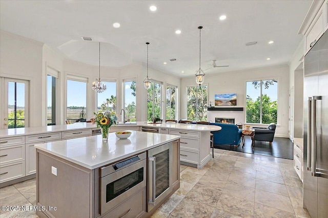 408 Osprey Lookout Ct Unit 29, Ponte Vedra Beach, FL 32082 - kitchen featuring a lit fireplace, a large island with sink, light countertops, a sink, and recessed lighting