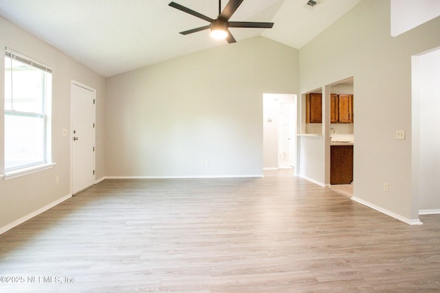 unfurnished living room with high vaulted ceiling, light wood-style flooring, baseboards, and a ceiling fan