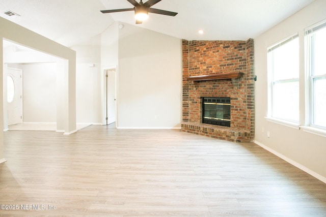 unfurnished living room with a fireplace, light wood finished floors, a ceiling fan, and visible vents