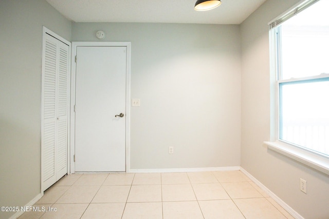 unfurnished bedroom featuring baseboards and tile patterned floors