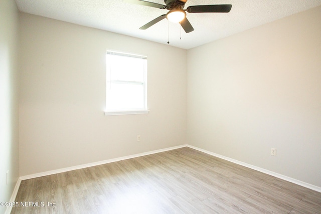 empty room with baseboards, ceiling fan, and wood finished floors