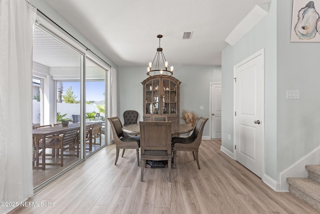 109 Redbud Ln, Yulee, FL 32097 - dining room featuring stairs, visible vents, an inviting chandelier, and light wood finished floors