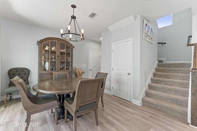109 Redbud Ln, Yulee, FL 32097 - dining area featuring an inviting chandelier, stairs, light wood-style flooring, and visible vents