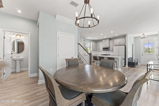 109 Redbud Ln, Yulee, FL 32097 - dining space featuring baseboards, light wood-type flooring, a chandelier, and visible vents