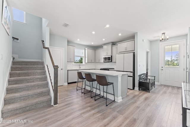 109 Redbud Ln, Yulee, FL 32097 - kitchen featuring visible vents, tasteful backsplash, freestanding refrigerator, dishwashing machine, and a breakfast bar