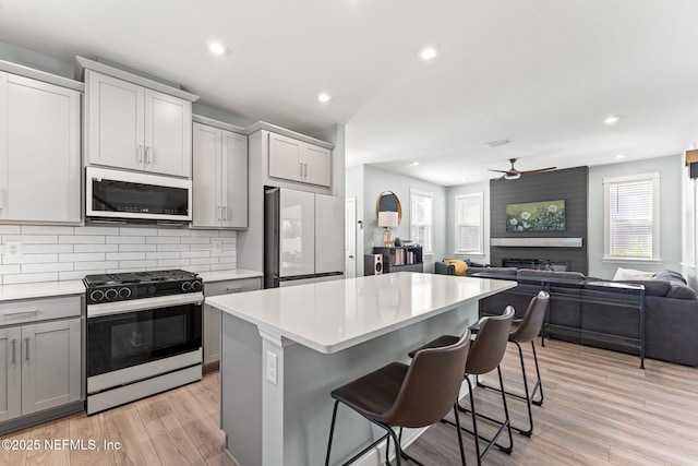 109 Redbud Ln, Yulee, FL 32097 - kitchen featuring white appliances, a center island, open floor plan, a kitchen bar, and gray cabinetry
