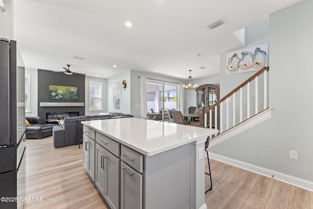 109 Redbud Ln, Yulee, FL 32097 - kitchen featuring gray cabinetry, ceiling fan with notable chandelier, light wood finished floors, and visible vents