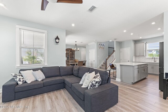 109 Redbud Ln, Yulee, FL 32097 - living room featuring visible vents, stairs, ceiling fan with notable chandelier, recessed lighting, and light wood-style flooring