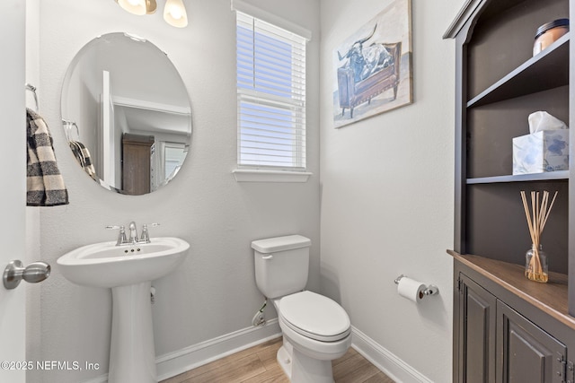 109 Redbud Ln, Yulee, FL 32097 - half bathroom featuring a sink, baseboards, toilet, and wood finished floors