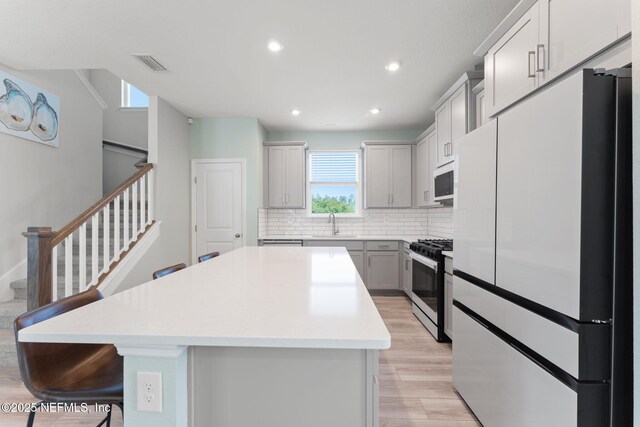 109 Redbud Ln, Yulee, FL 32097 - kitchen with a center island, tasteful backsplash, a sink, light wood finished floors, and white appliances