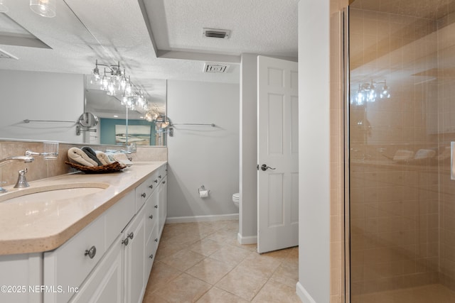 bathroom with a textured ceiling, visible vents, tile patterned flooring, a shower stall, and a sink