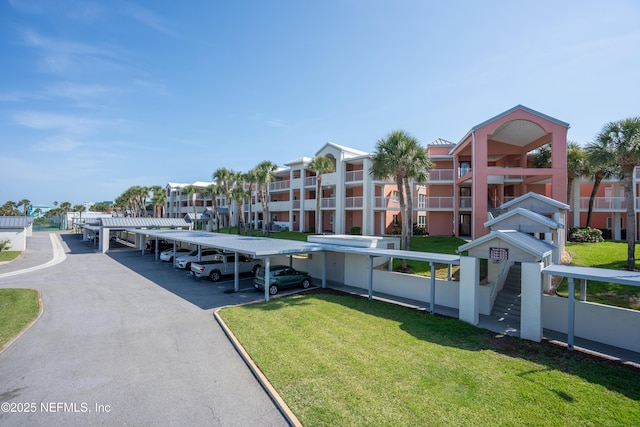 view of property's community featuring covered parking and a yard