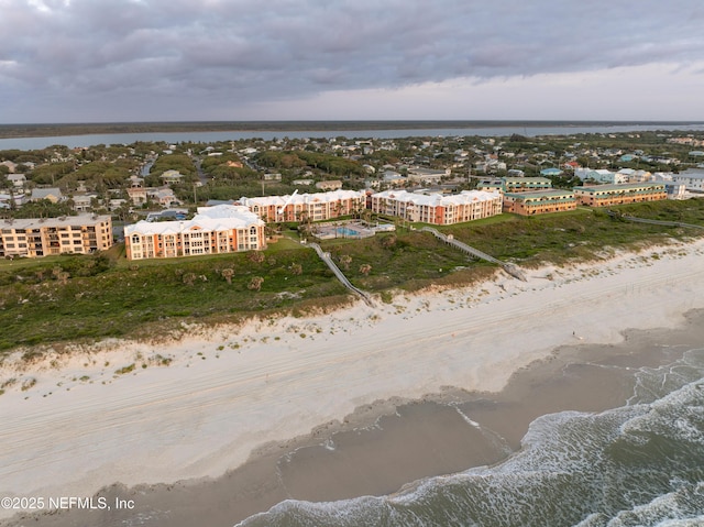 birds eye view of property with a water view and a view of the beach