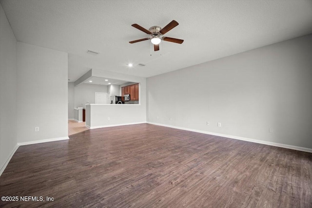 unfurnished living room with ceiling fan, visible vents, dark wood finished floors, baseboards, and recessed lighting