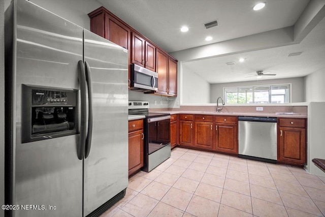 kitchen featuring visible vents, light countertops, a sink, light tile patterned floors, and stainless steel appliances