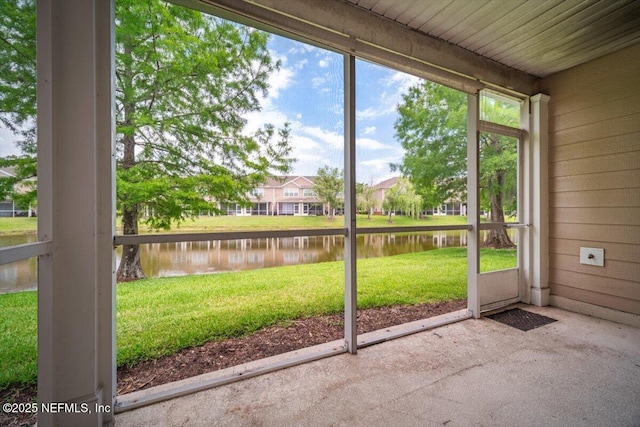unfurnished sunroom featuring a residential view and a water view